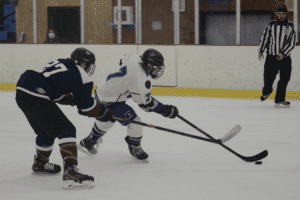 Daniel Ostrager skates past a Rye Town/Harrison defender on Jan. 8, 2022. Ostrager had two goals in the Huguenots’ 7-2 victory.